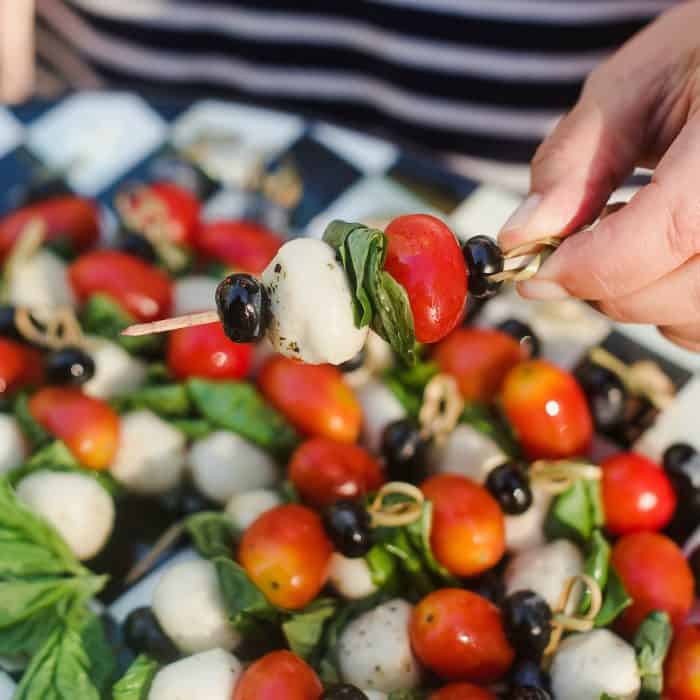 holding a Caprese Skewers