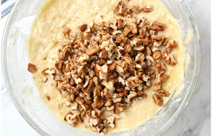 adding walnuts to banana bread batter