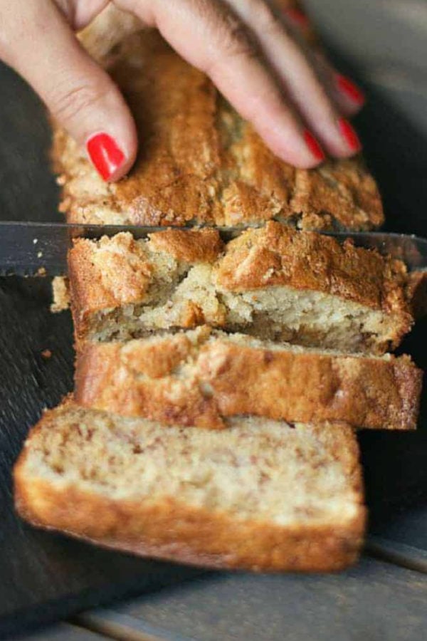 slicing a loaf of sour cream banana bread