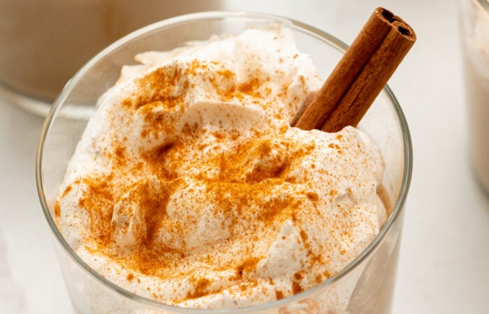 whipped cream on pudding garnished with cinnamon stick