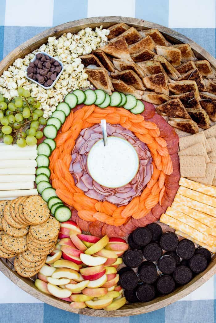 looking down on a beautiful wood board filled with Grilled Cheese sandwiches and charcuterie foods