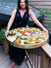 woman holding an epic mini tortellini kebabs charcuterie board