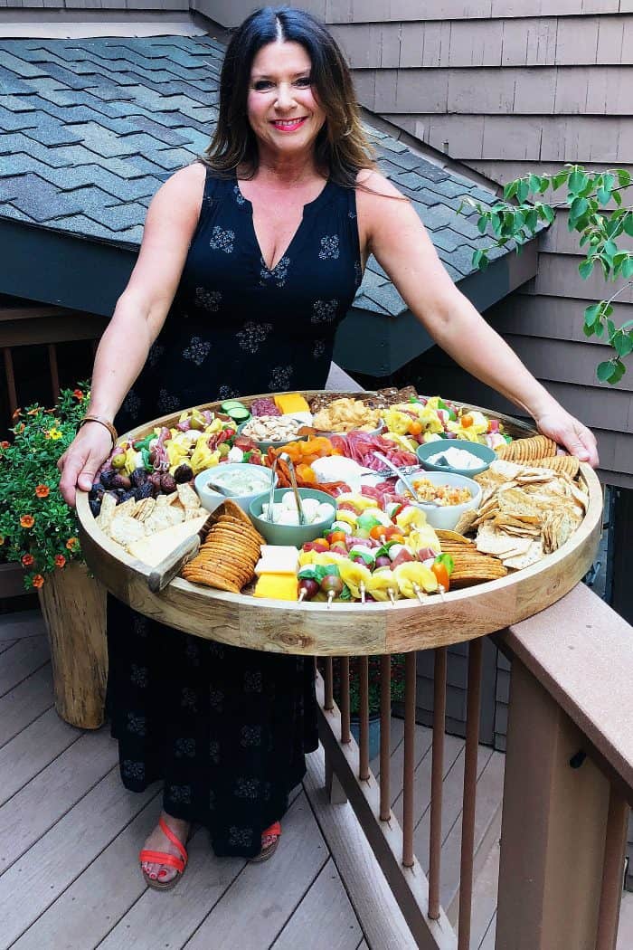 a woman holding an EPIC Mini Tortellini Kebabs Charcuterie Board