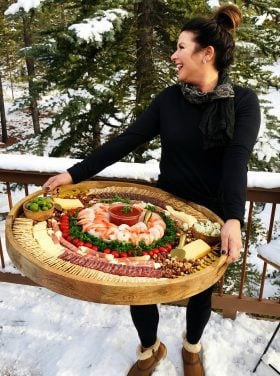 woman holding a big board with shrimp cocktail