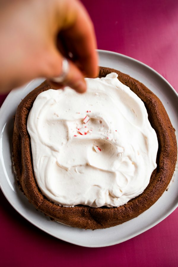 sprinkling peppermint on a flourless chocolate cake