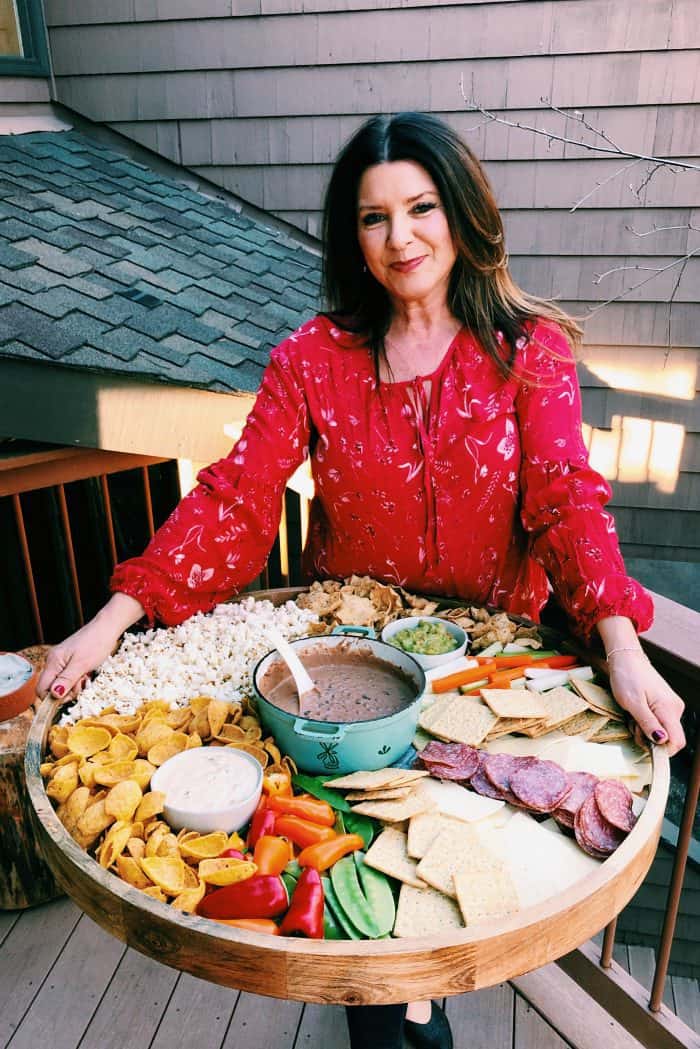 woman in red shirt holding an epic Game Day Charcuterie Board