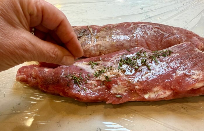 adding chopped rosemary to pork