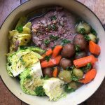 blue dutch oven of corned beef and cabbage