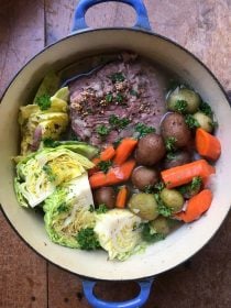 blue dutch oven of corned beef and cabbage