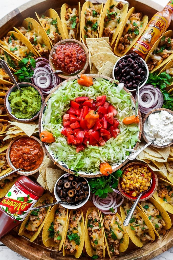 large round platter surrounded with tacos and toppings