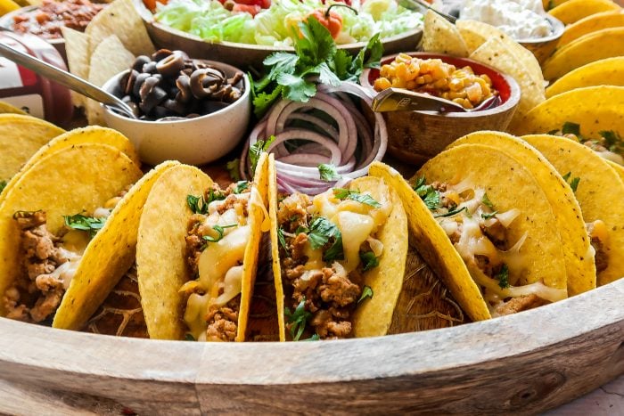 large round platter surrounded with tacos and toppings