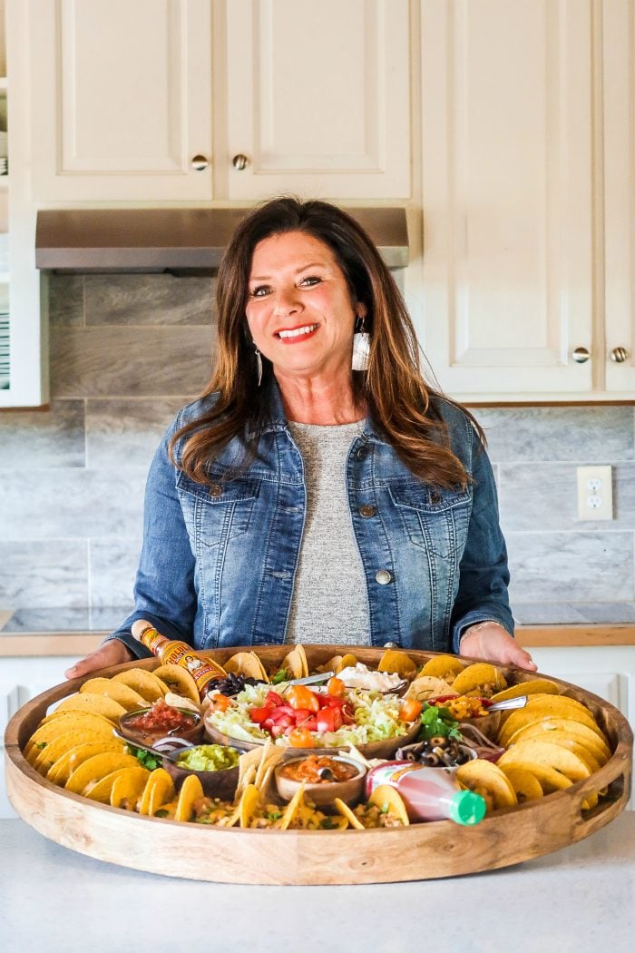 woman holding an epic round taco board