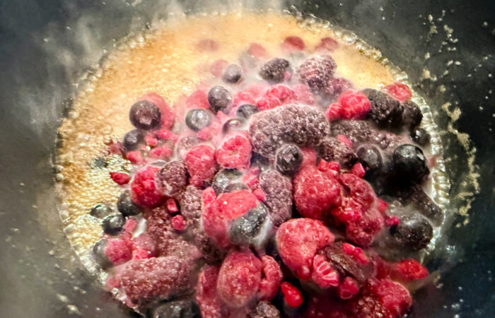 adding frozen berries to hot butter
