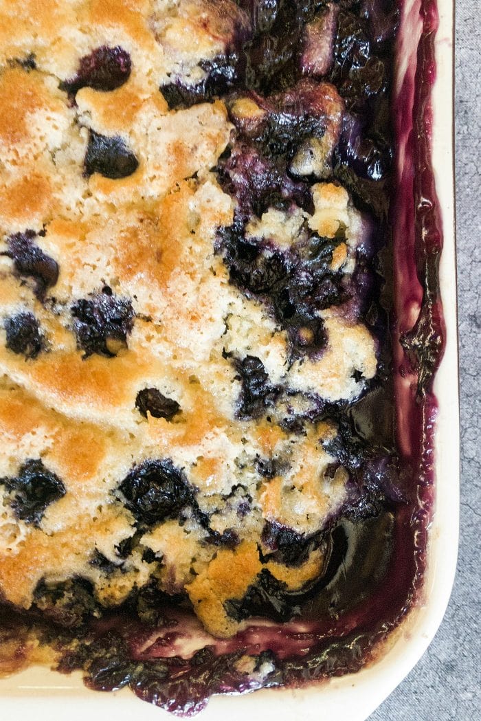 cooked blueberry cobbler with a light brown crust with blueberries peeking through