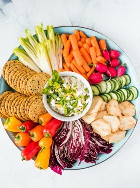 a round platter of veggies and dip