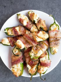 a white plate of Bacon-Wrapped Air Fryer Cheesy Jalapeño Poppers