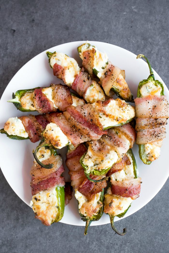 a round white plate of Bacon-Wrapped Cheesy Jalapeño Poppers