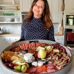 woman holding an epic round cheese board