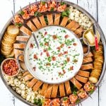 clam chowderin a big pot, on a round board with bread and shrimp cocktail cups