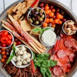 round charcuterie board with cured meats and cheese