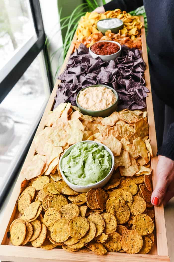 a rectangular 42 x 12 inch board filled with chips and dips