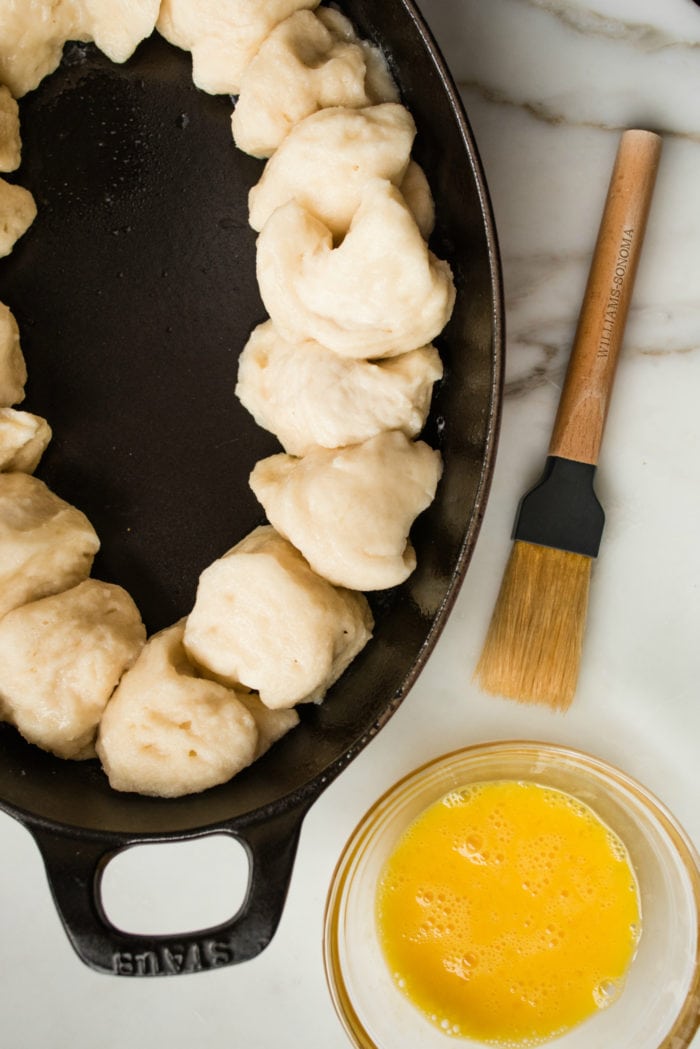 overhead shot of a plate of pretzel dough next to a bowl of melted butter