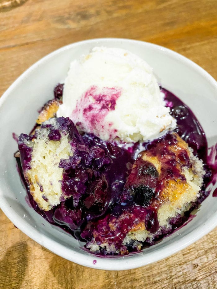 bowl of blueberry cobbler with vanilla ice cream