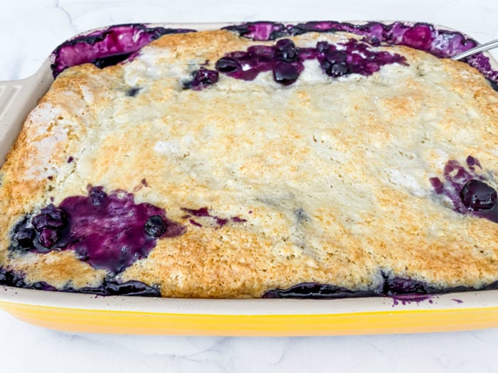 9x13 yellow pan of juicy blueberry cobbler