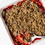 large spoonful of rhubarb and strawberry crisp with poppyseed topping