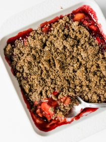 large spoonful of rhubarb and strawberry crisp with poppyseed topping