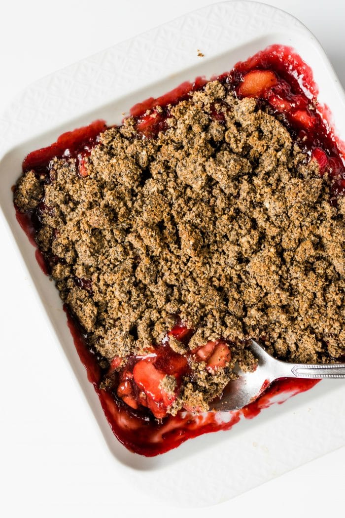 large spoonful of rhubarb and strawberry crisp with poppyseed topping