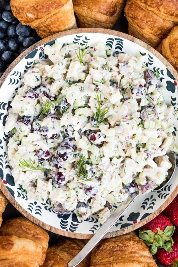 a bowl of chicken salad with purple grapes