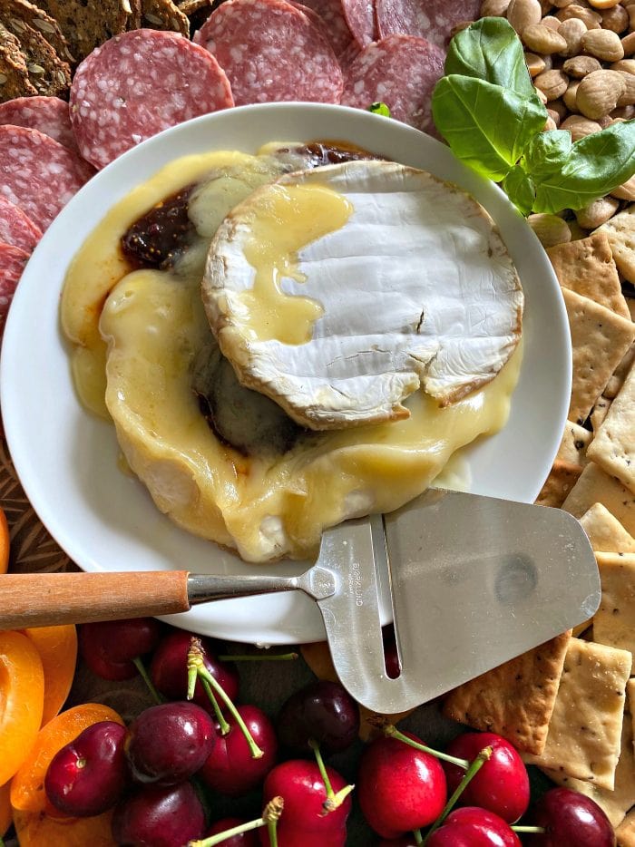 a round of melted brie cheese with chili fig