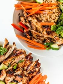 grilled chickcen strips on a plate and a bowl of rice and chicken