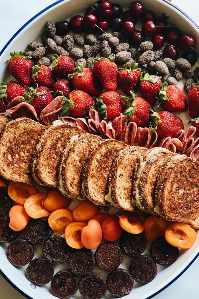 close up of tray with grilled cheese sandwiches and fresh fruit