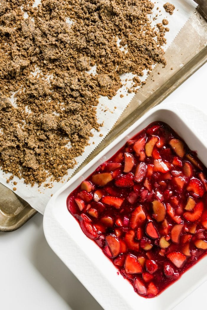 poppyseed crisp topping with a baking dish of strawberries and rhubarb