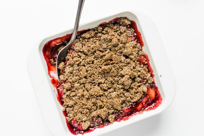 white square baking dish of strawberry rhubarb crisp