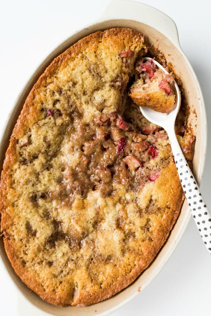 oval baking dish of rhubarb strawberry cobbler with a polka dot spoon