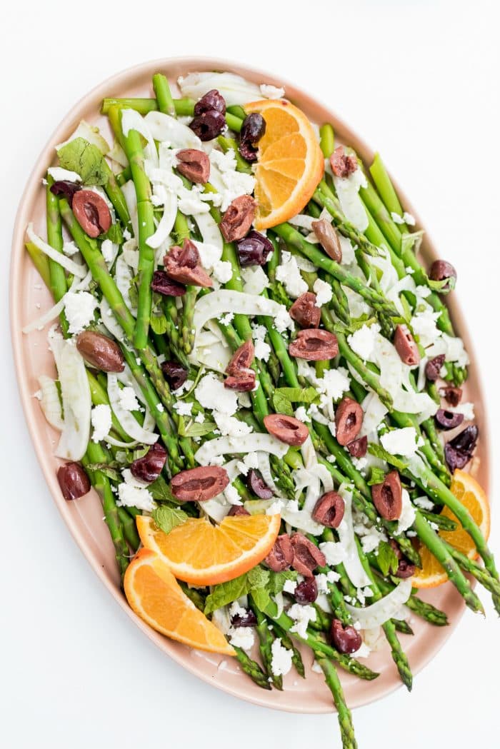 a soft pink plate filled with a Shaved Fennel Asparagus Salad