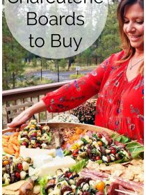 woman in red shirt holding an epic wood board with appetizers