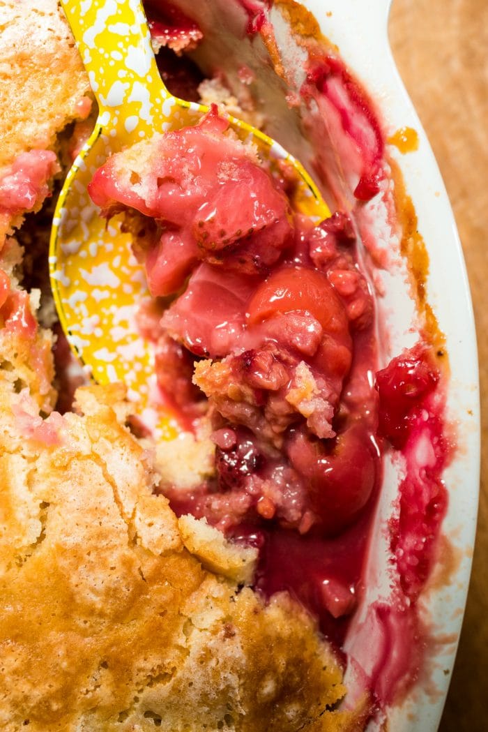 close up spoonful of fresh summer berry cobbler