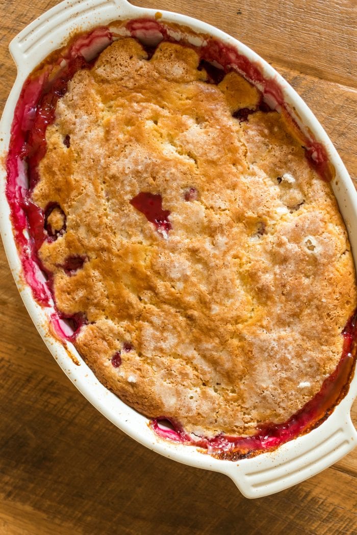 oval pan of summer berry cobbler with red cherries