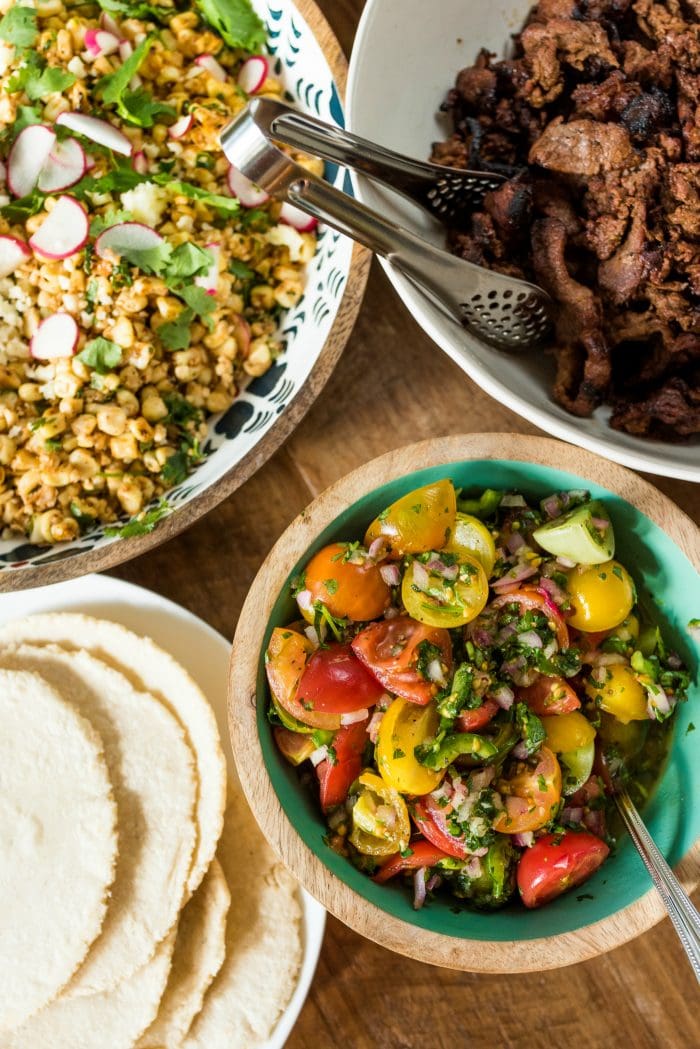 close up of homemade salsa, corn salad, beef, and tortillas