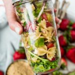 close up canning jar filled with bowtie pasta salad