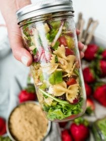 close up canning jar filled with bowtie pasta salad