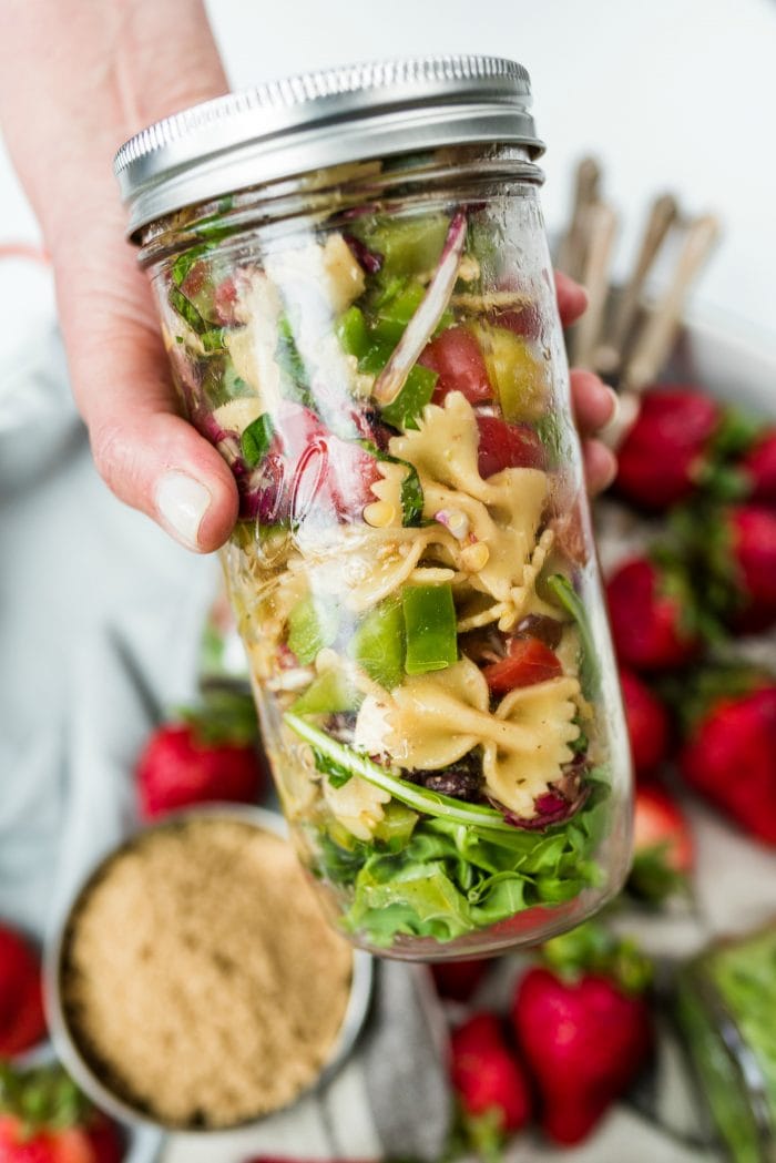 close up canning jar filled with bowtie pasta salad