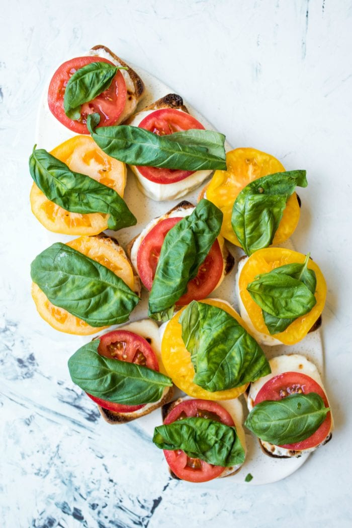 open face sliders with cheese, tomatoes, and basil