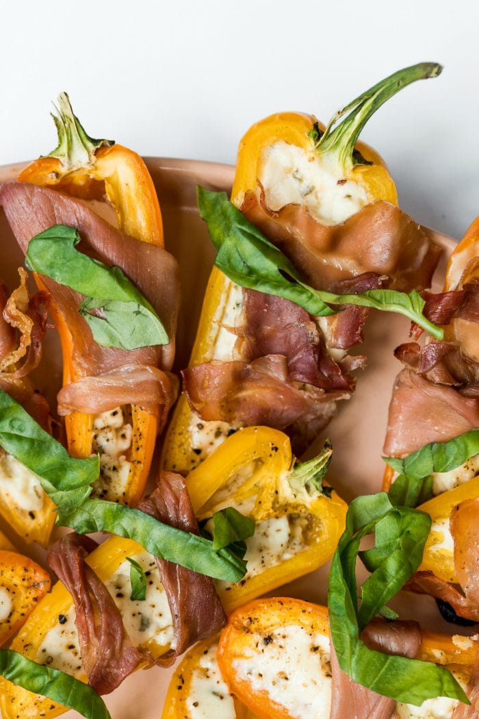 close up of Prosciutto-Wrapped Mini Peppers garnished with fresh basil