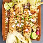 plate of charred grilled corn on the cob (with husks)