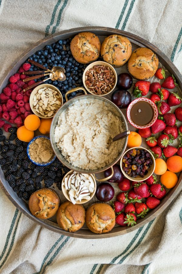 looking down on a round tray with an oatmeal breakfast (pot of oatmeal and toppings)